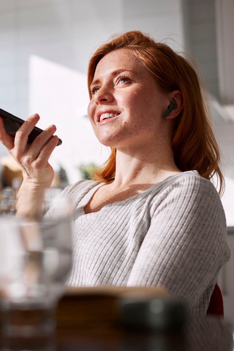 kvinna som håller i mobiltelefon